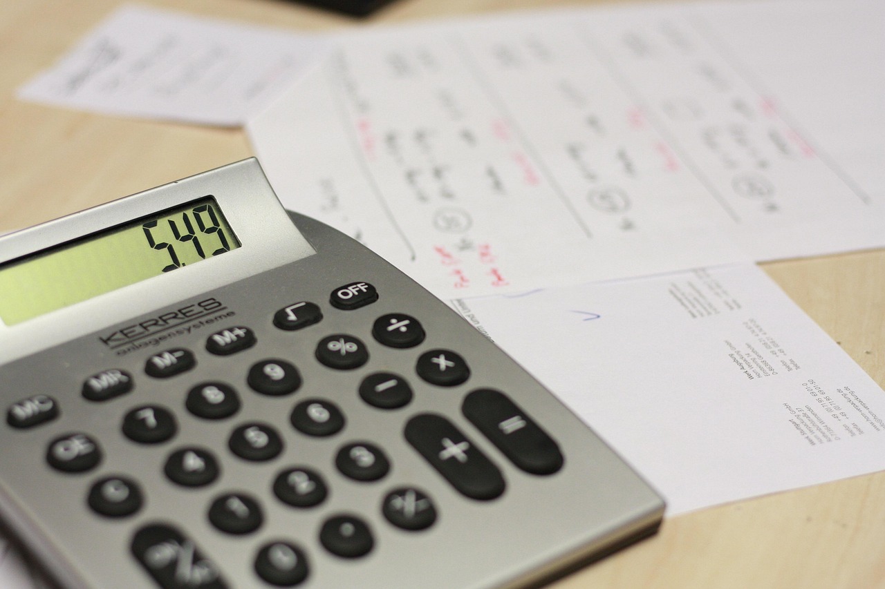 Trade receivables days: a calculator beside invoices and handwritten accounts on a desk