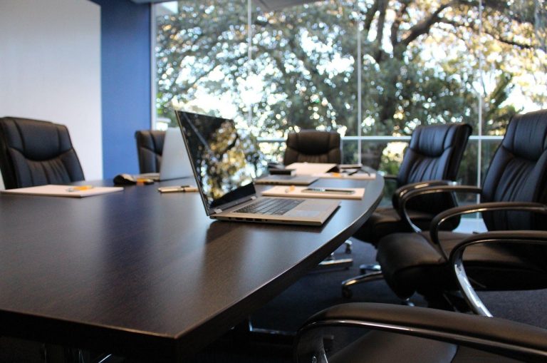 Rights issue vs IPO: empty company boardroom with laptops and notepads on the meeting table