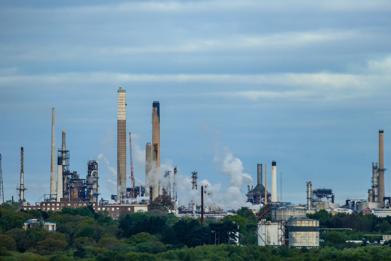 Reliance Q2 results: oil refinery towers and chimneys against a cloudy sky