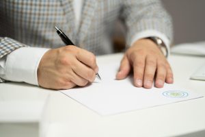 Risk factors in RHP: an investor signing a document at a desk after reading the fine print