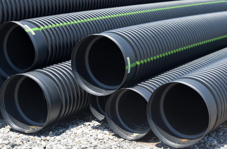 Supreme Industries Q2 results: stacked black plastic pipes at a construction site, the core of its piping business