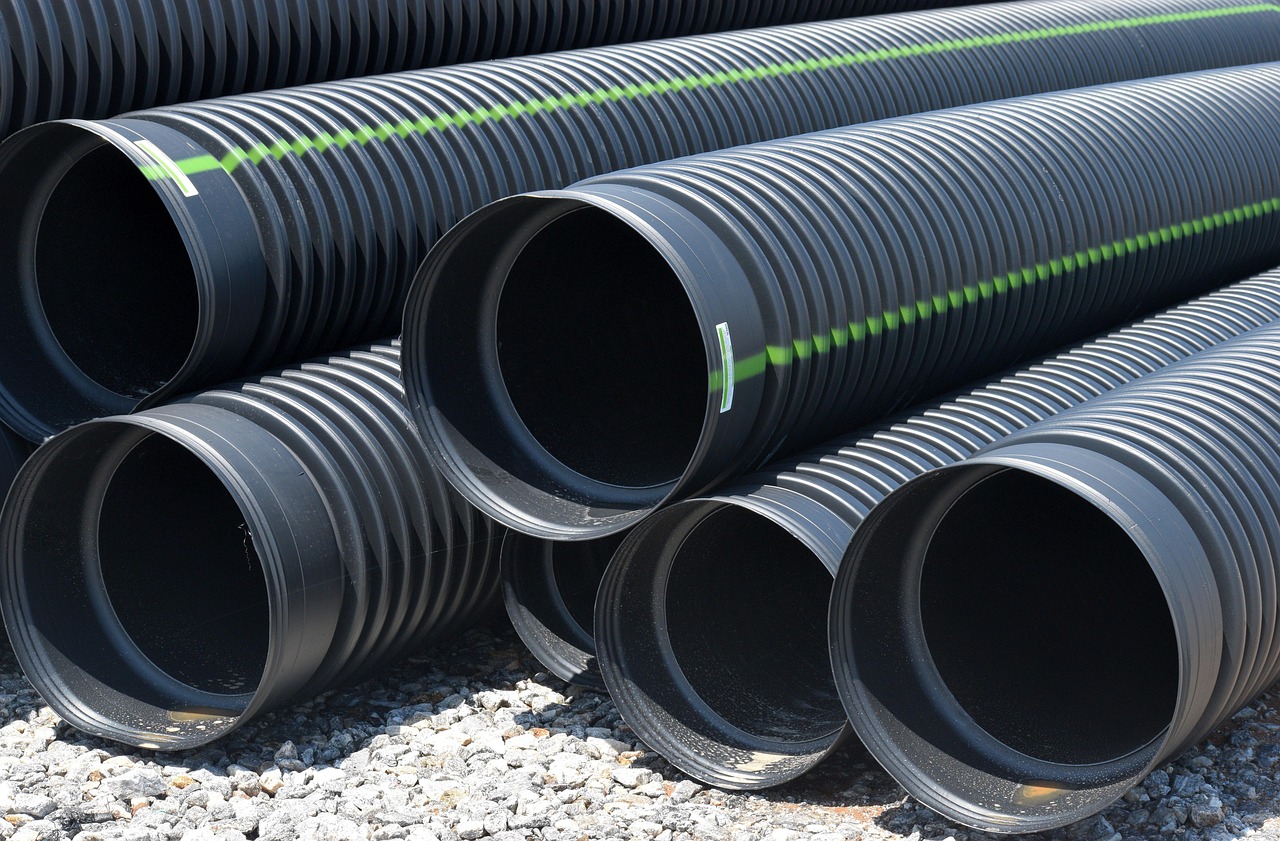 Supreme Industries Q2 results: stacked black plastic pipes at a construction site, the core of its piping business