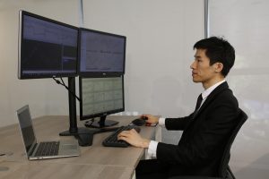 Three outside up pattern: a trader at a multi-monitor desk studying price action