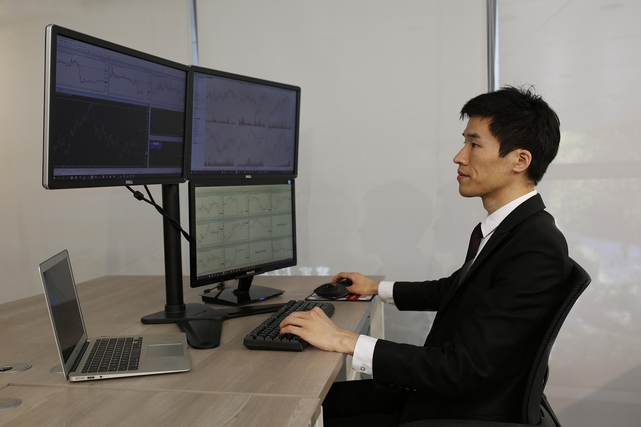 Three outside up pattern: a trader at a multi-monitor desk studying price action