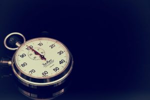 Time stop in trading: a mechanical stopwatch with a red second hand on a dark background