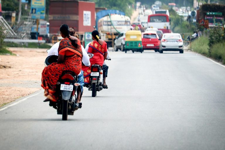 TVS Motor Q2 results: motorcycles and an auto-rickshaw on a busy Indian highway