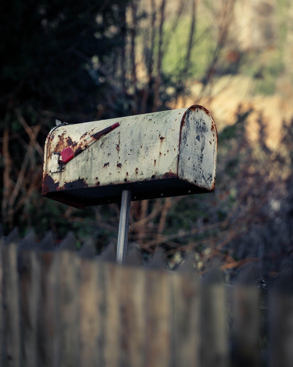 Unclaimed dividend: an old weathered mailbox left on its post