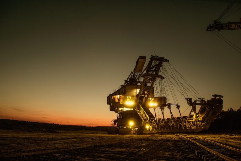 Vedanta Q2 results: a large mining excavator lit up at dusk at an open-pit mine