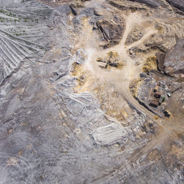 Vedanta zinc expansion: aerial view of an open-pit mine with terraced benches and haul roads