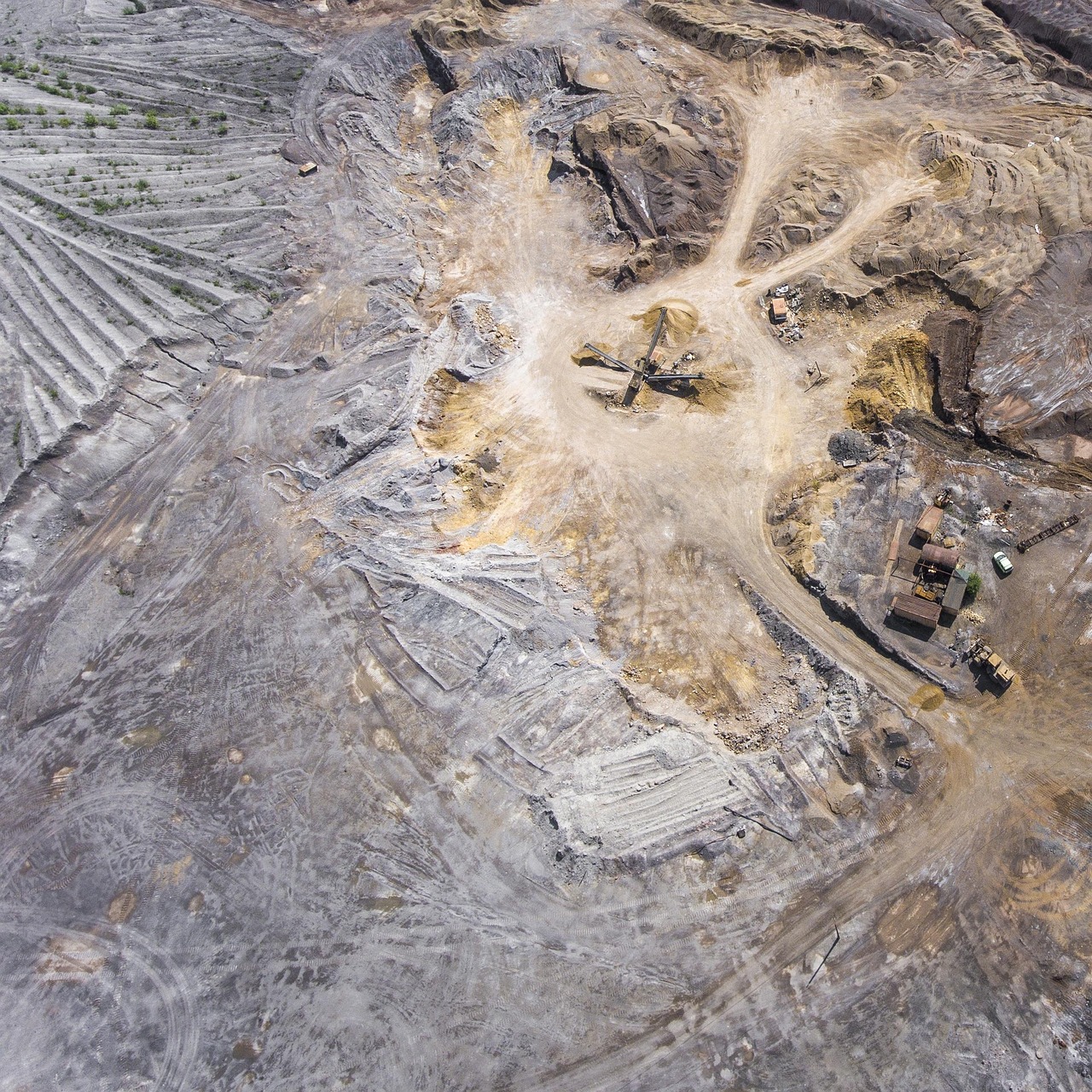 Vedanta zinc expansion: aerial view of an open-pit mine with terraced benches and haul roads