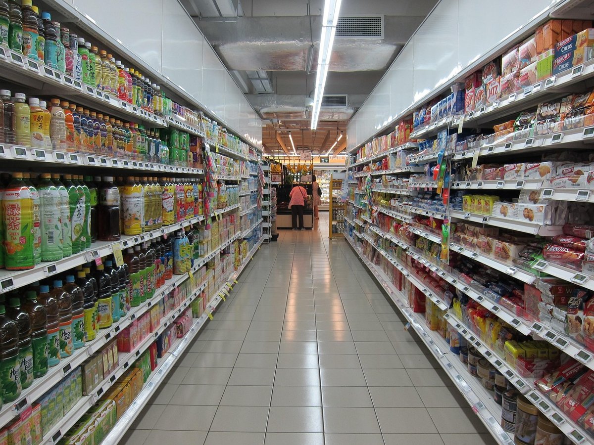 Volume growth in FMCG results: a long supermarket aisle stocked with packaged goods and bottles