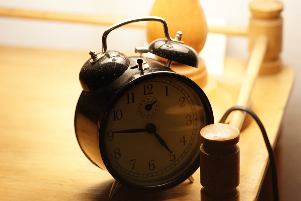 Weekend effect: a vintage alarm clock on a wooden desk, a reminder of the Monday open after the weekend
