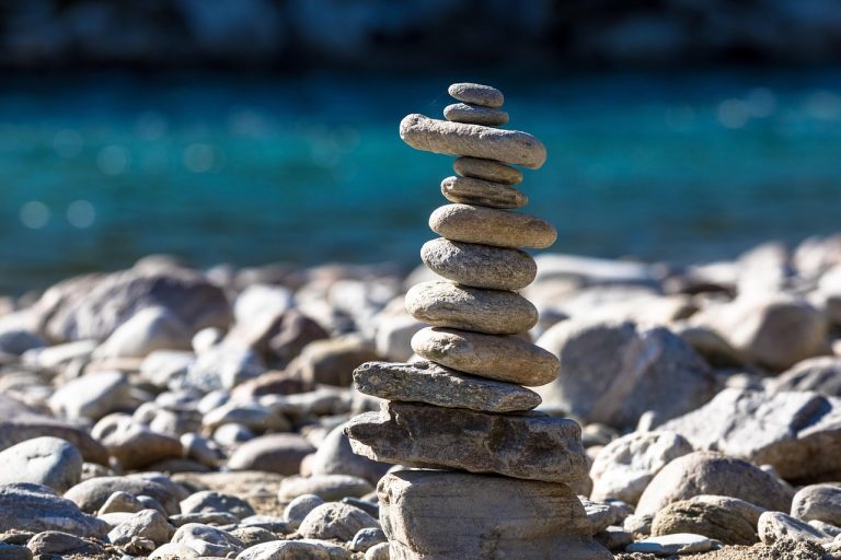 Zmijewski score concept: a tall stack of balanced river stones, a reminder of how fragile a leveraged balance sheet can be