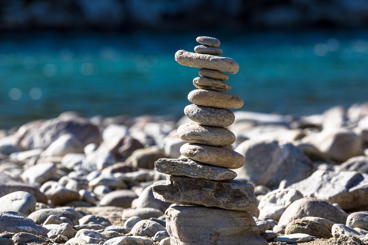 Zmijewski score concept: a tall stack of balanced river stones, a reminder of how fragile a leveraged balance sheet can be